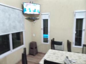 um quarto com uma mesa e uma televisão na parede em Cabañas Raíces de la Estancia 2 em El Amparo