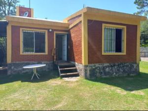 una pequeña casa con una mesa en el patio en Cabañas Raíces de la Estancia 2 in 