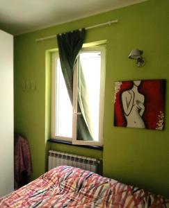 um quarto verde com uma cama e uma janela em vista mare em Portovenere