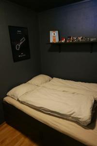 a unmade bed in a bedroom with a shelf at Cozy apartment with sea view in Tromsø