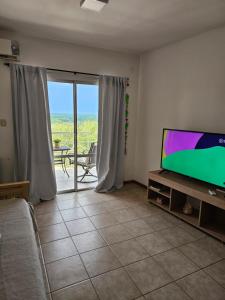 sala de estar con TV de pantalla plana y sofá en Departamento Leloir Neuquén en Neuquén