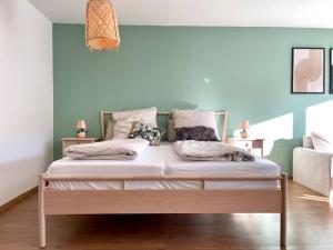 un lit avec deux oreillers dessus dans une chambre dans l'établissement BERGfeeling mit Oberstaufen PLUS, à Oberstaufen