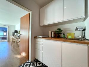 a kitchen with white cabinets and a counter top at BERGfeeling mit Oberstaufen PLUS in Oberstaufen