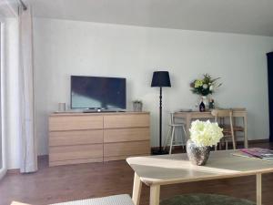 a living room with a tv on a wooden dresser at BERGfeeling mit Oberstaufen PLUS in Oberstaufen