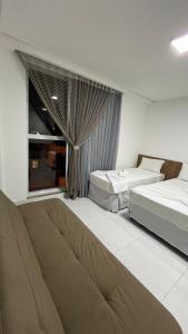 a hotel room with two beds and a window at EL SHADDAI HOTEL in João Pessoa