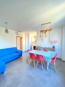 un soggiorno con divano blu, tavolo e sedie di Trilocale GIGLIO IN RESIDENCE, CON ARIA CONDIZIONATA ED INGRESSO IN PISCINA a Marcelli