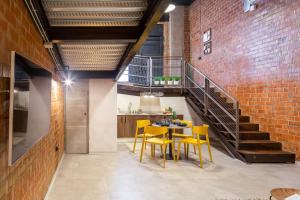 uma sala de jantar com cadeiras amarelas e uma parede de tijolos em ART LOFTS Valencia by Benisur em Valência