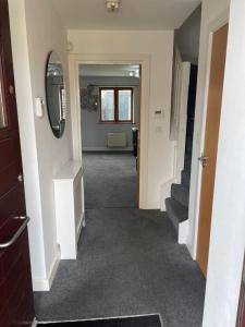 a hallway of a house with stairs and a mirror at The Comfy place Shared in Dallington