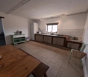 a large kitchen with a table and a refrigerator at Casa Rural Muchichafe in Puerto del Rosario