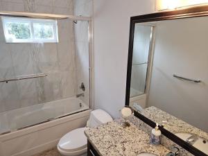 a bathroom with a shower and a toilet and a sink at Oscar INN & 2bd Family Suite or Private Room in Abbotsford