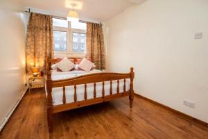 a bedroom with a wooden bed and a window at 3 Bedroom Flat in Central London in London