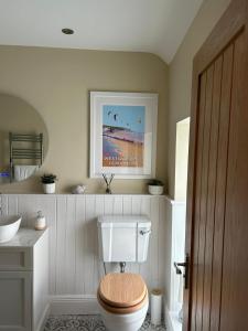 a bathroom with a toilet with a wooden seat at Applestow Cottage in Northam