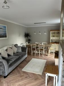 a living room with a couch and a dining room at Applestow Cottage in Northam