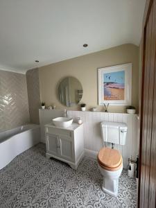 a bathroom with a sink and a toilet and a tub at Applestow Cottage in Northam