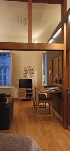 un soggiorno con tavolo e una sala da pranzo di L' Appart du Centre Historique Charme et confort a Arles