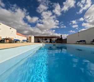 a swimming pool with blue water in front of a building at Casa Rural Muchichafe in Puerto del Rosario
