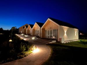 a row of lodges at night with lights at Kajan Mielenko in Mielenko