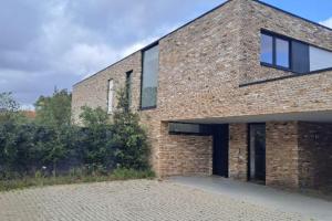 a brick house with windows on the side of it at Modern spatious house near Bruges in Bruges