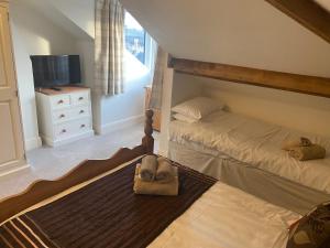 a bedroom with two beds and a television in it at County Loft Penthouse Apartment in Whitby