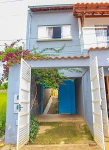a blue house with an open door and a hallway at Casa Da Cléo Carrancas in Carrancas