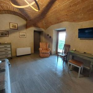 a living room with a desk and a chair at Istanti - Salvia in Costigliole Saluzzo +25 photos