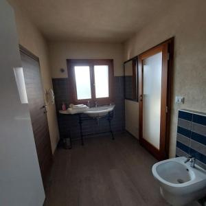 a bathroom with a sink and a toilet and a window at Istanti - Salvia in Costigliole Saluzzo