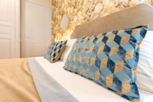 Una cama con almohadas azules y amarillas. en Guest House 73, en Cagliari