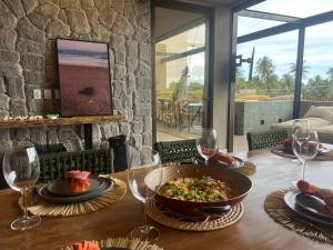 a table with a bowl of food and wine glasses at Kanui Mar (cobertura garden) in São Miguel dos Milagres