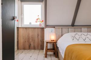 sypialnia z łóżkiem, oknem i stołem w obiekcie Zandvoortferienwohnungen w Zandvoort