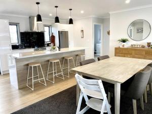 a kitchen with a wooden table and bar with stools at Beautiful Home In Mangakino in Mangakino