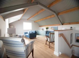 a living room with a vaulted ceiling and a table and chairs at Sligo Sea Barn in Sligo