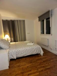 Schlafzimmer mit einem Bett und einem Fenster in der Unterkunft L'adorable Maison des Clients 15min de Paris in Houilles