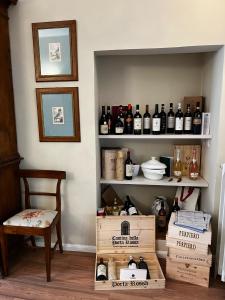 a room with shelves with bottles of wine and a chair at Maestra Exclusive Chianti House, Tuscany in Poggibonsi