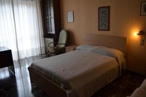 1 dormitorio con 1 cama y 1 silla en Eleganza vicino al centro di Torino en Turín