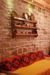 a room with a brick wall with shelves and a couch at Chouliarades Tzoumerka in Chouliarades