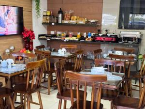 a restaurant with wooden tables and chairs and a counter at POUSADA CASA DA CLAUDIA MARAGOGI in Maragogi