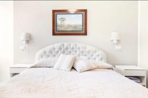 biała sypialnia z dużym łóżkiem z białym zagłówkiem w obiekcie Alloggio da sogno nel verde di Posillipo w mieście Napoli
