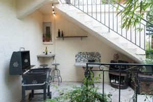an outdoor patio with a stove and a staircase at VILLA ISABELLE -2 Appartements - 2 Jacuzzi privatifs in Saint-Étienne-de-Fontbellon