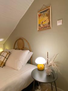ein Schlafzimmer mit einem Bett und einem Tisch mit einer Lampe in der Unterkunft A22 - Les Cosy De Nancy - Le bohème chic 4* in Nancy
