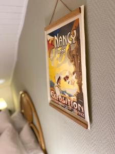 ein Poster hängt an einer Wand mit einer Schere in der Unterkunft A22 - Les Cosy De Nancy - Le bohème chic 4* in Nancy