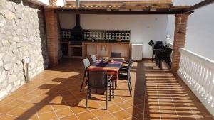 comedor con mesa y algunas sillas en Villa Cuesta Colorada, en Huétor Santillán