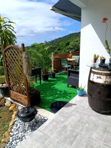 a patio with a table and a barrel and green grass at Poz Tropicale in Schœlcher
