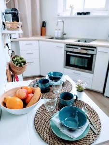 - une cuisine avec une table et un bol de fruits dans l'établissement Plage & Confort Appartement 3 pièces Parking clim et wifi, à Antibes