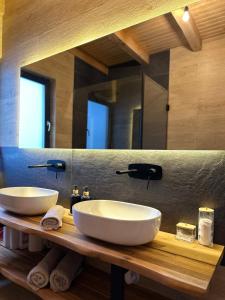 a bathroom with two sinks and a large mirror at Cabana Stil A in Mărişel