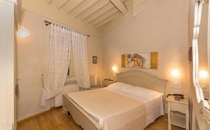 a bedroom with a white bed and a window at Residenza d'Epoca Relais I Miracoli in Pisa +54 photos