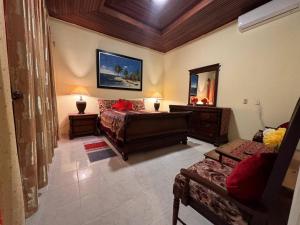 a bedroom with a bed and a mirror and a couch at Residencia Foreman De La Paz in Santo Domingo