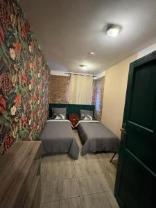 sypialnia z 2 łóżkami i ścianą z kwiatami w obiekcie Stay in Poznan Tropical w Poznaniu