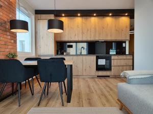 a kitchen with a table and chairs in a room at STARCO Apartamenty Centrum in Stargard