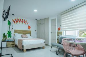 a bedroom with a bed and a table and chairs at HELICONIA Enjoy new comfortable studio apartment with terrace in Cali