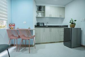 a kitchen with two chairs and a table and a sink at HELICONIA Enjoy new comfortable studio apartment with terrace in Cali